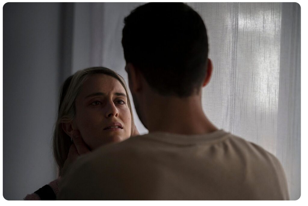 Kobieta patrząca z lękiem i troską na partnera, ilustrująca mechanizm współuzależnienia i utraty własnych granic w relacji.