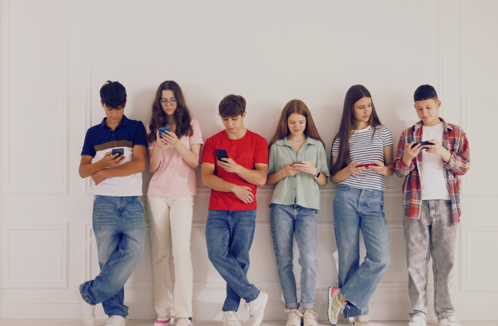 Zaniepokojony rodzic i nastolatek wpatrzony w ekran smartfona – symbol fonoholizmu i uzależnienia cyfrowego dzieci.